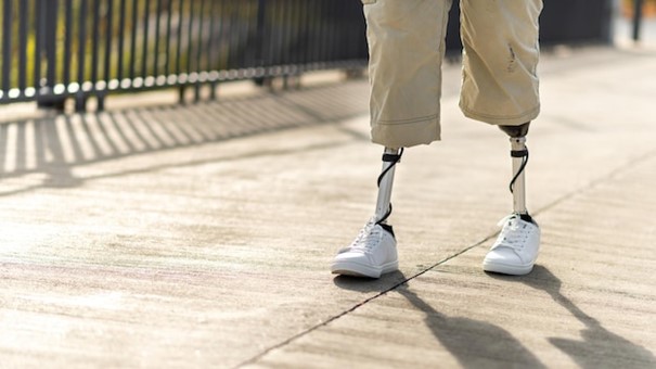 Free photo view of a walking man with prosthetic legs and white sneakers